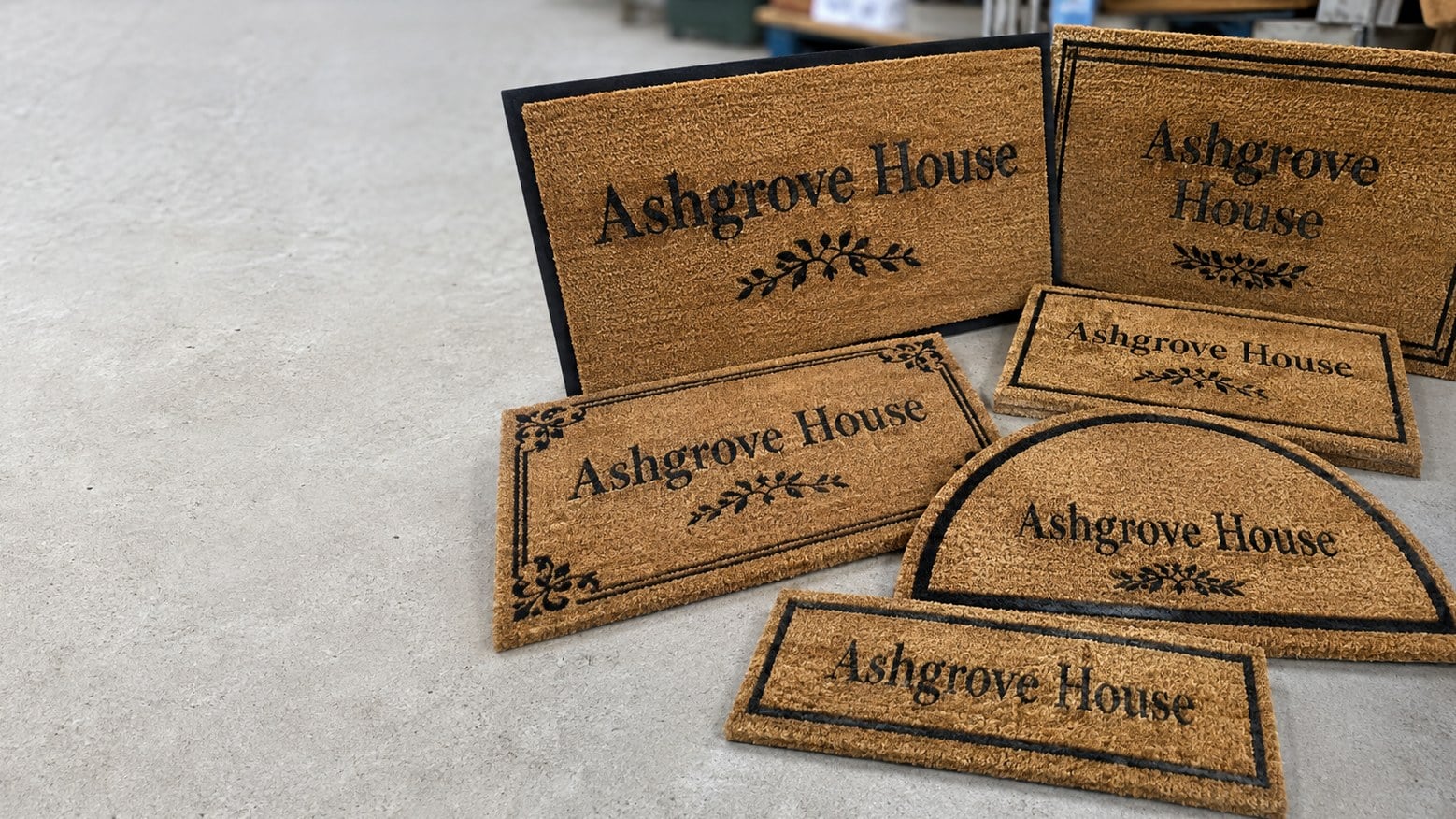 Custom printed doormats with a logo laid out on a warehouse floor